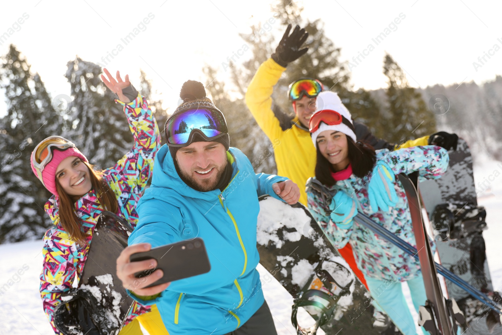 Photo of Group of friends taking selfie on snowy hill. Winter vacation