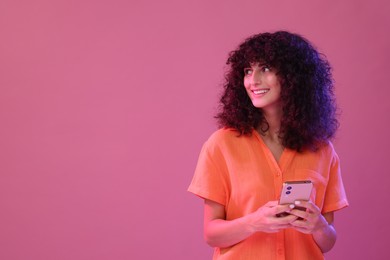 Woman sending message via smartphone on pink background, space for text