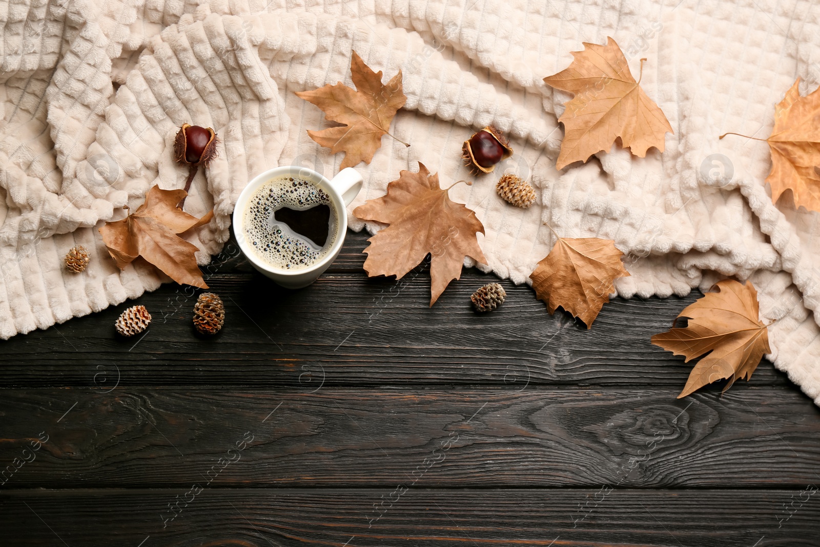 Photo of Flat lay composition with hot drink and warm plaid on black wooden table, space for text