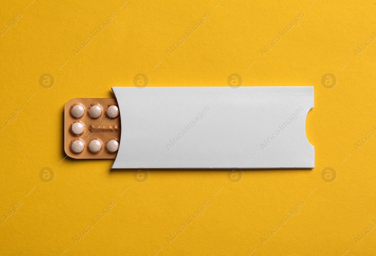 Photo of Birth control pills on yellow background, top view