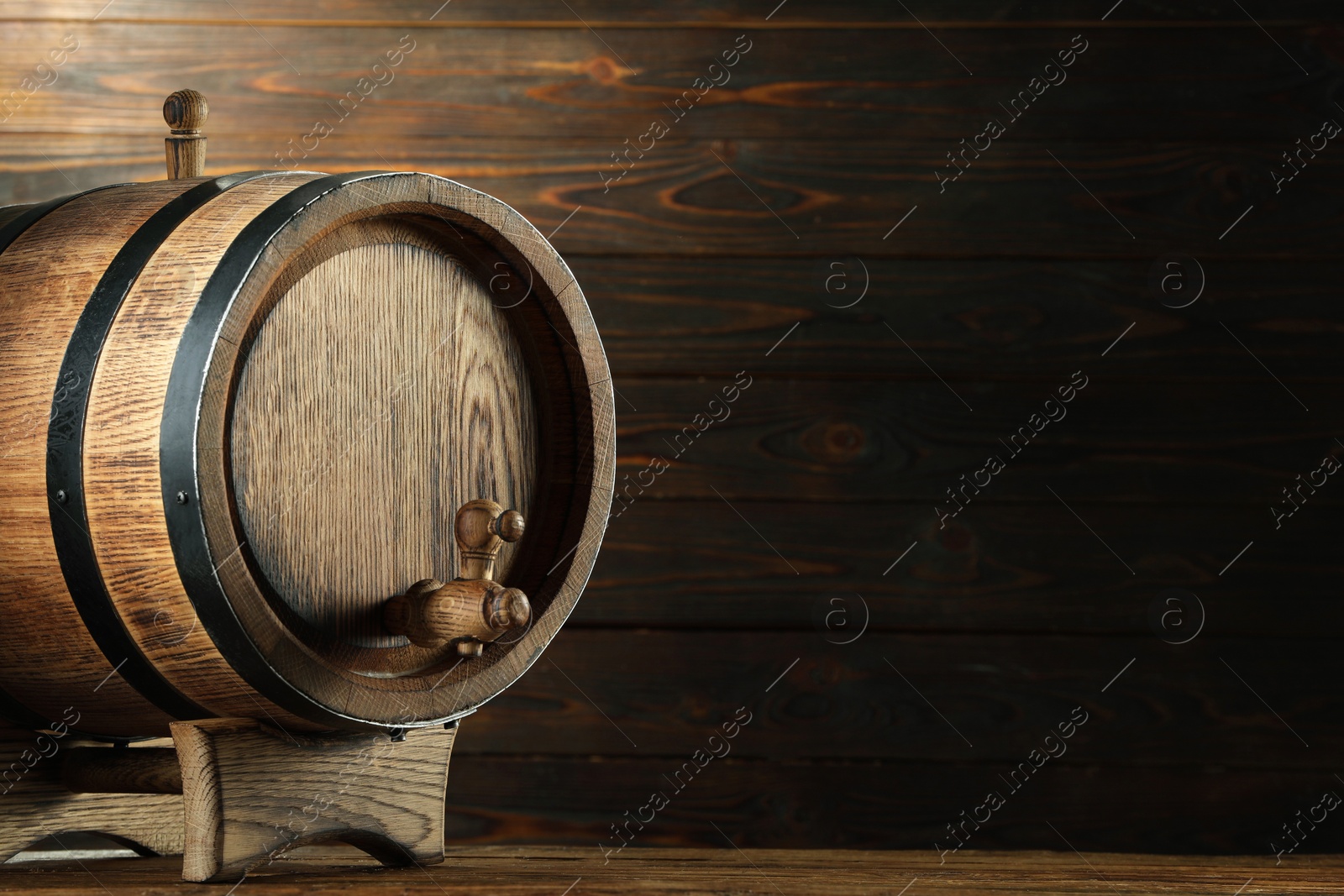 Photo of Wooden barrel with tap on table near wall. Space for text