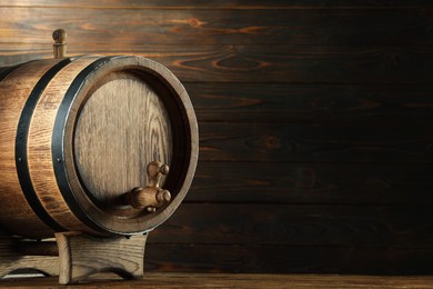 Photo of Wooden barrel with tap on table near wall. Space for text