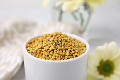 Photo of Fresh bee pollen granules on blurred background, closeup