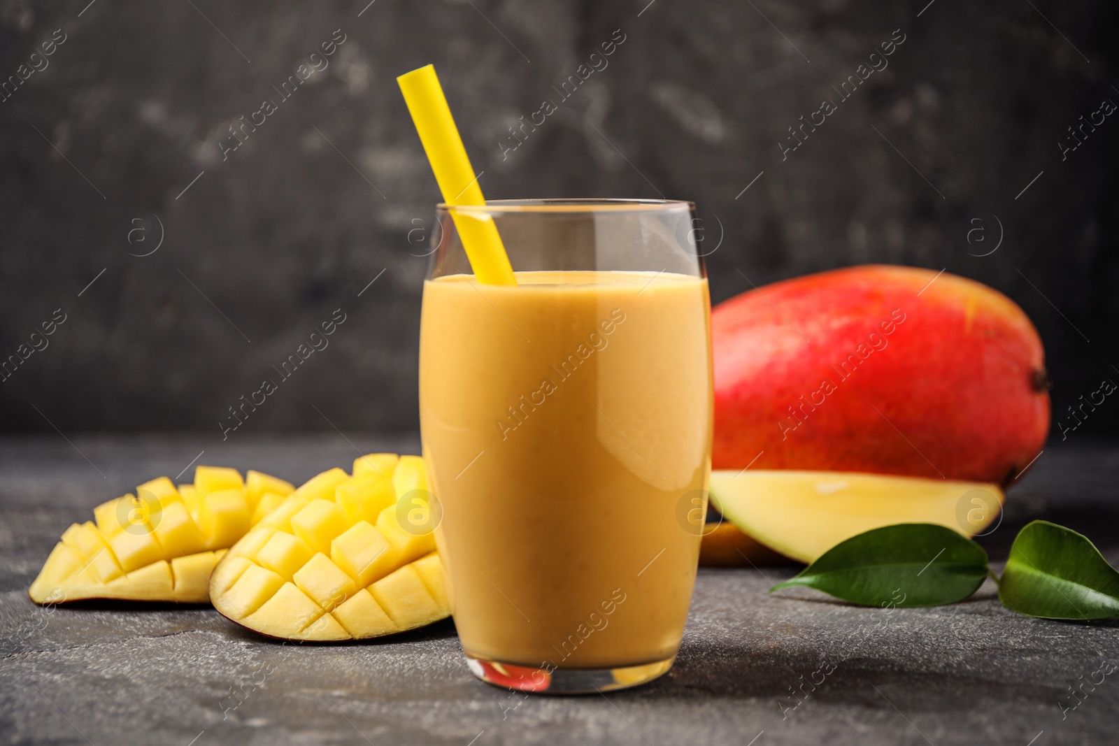 Photo of Fresh delicious mango drink on grey table