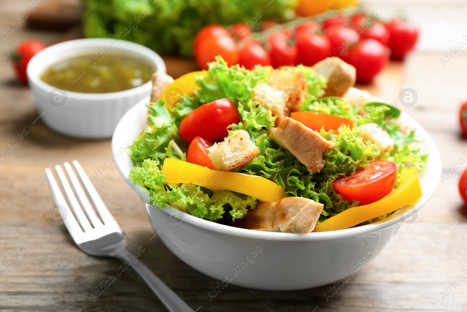 Photo of Delicious fresh chicken salad served on wooden table, closeup