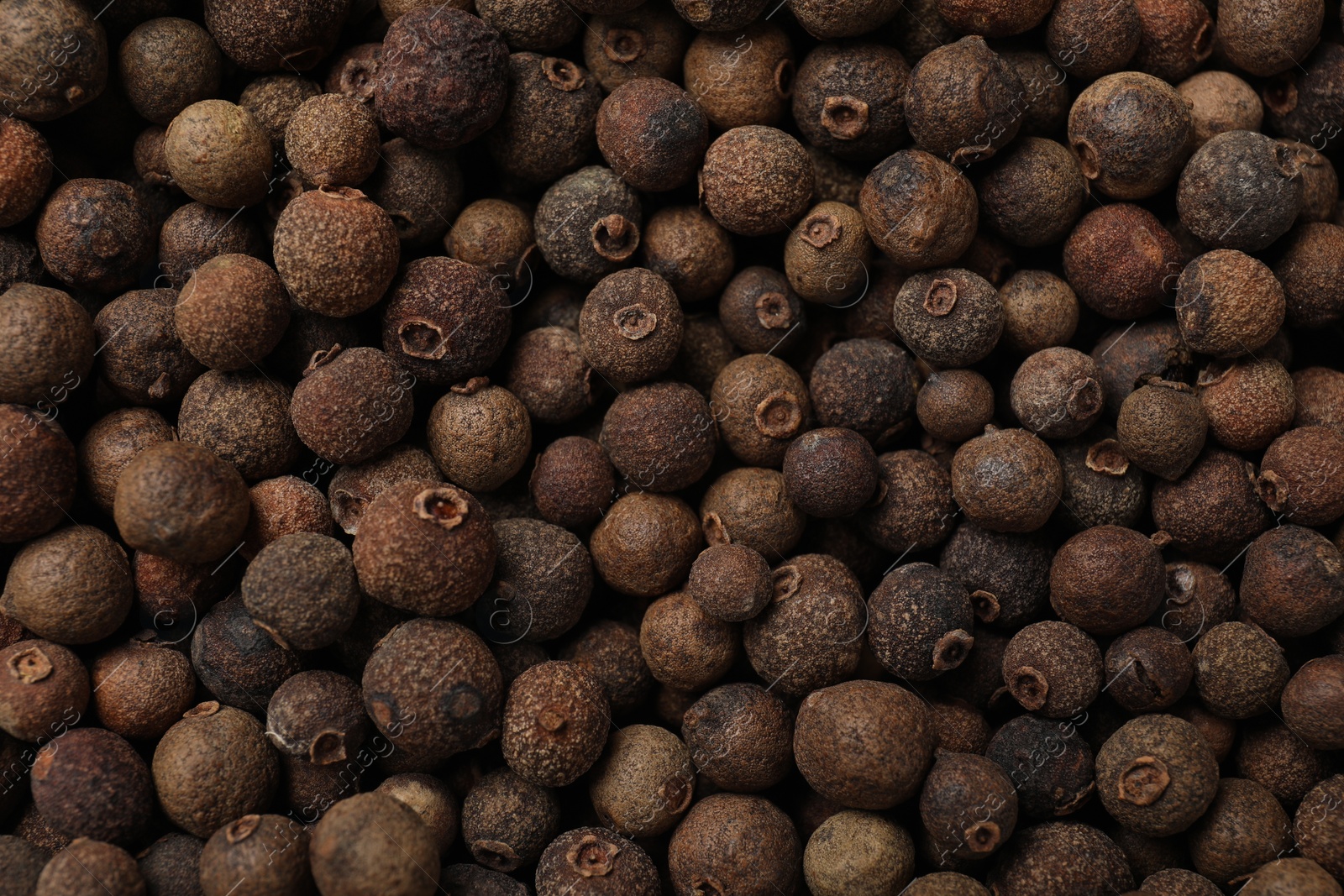 Photo of Aromatic allspice pepper grains as background, top view