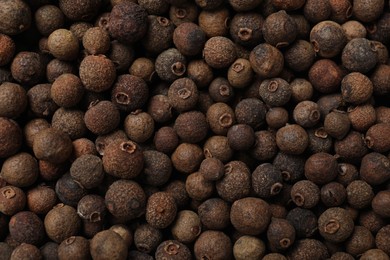 Photo of Aromatic allspice pepper grains as background, top view