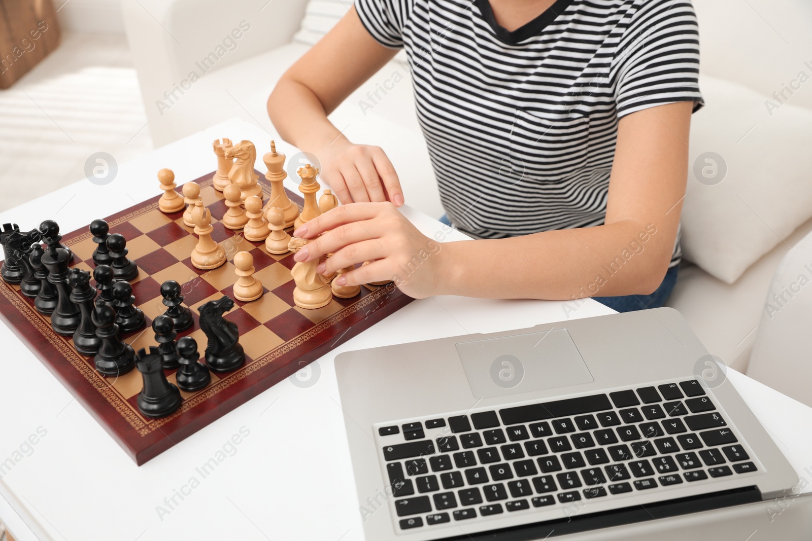 Photo of Woman playing chess with partner through online video chat at home, closeup