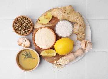 Photo of Flat lay composition with fresh marinade and different ingredients on white tiled table