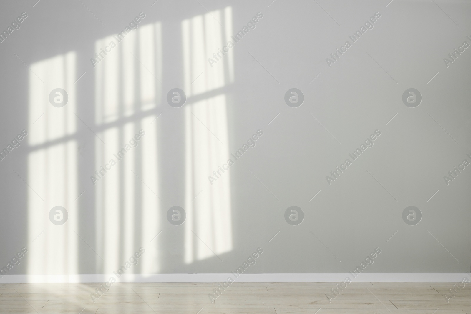 Photo of Light and shadows from window on wall indoors