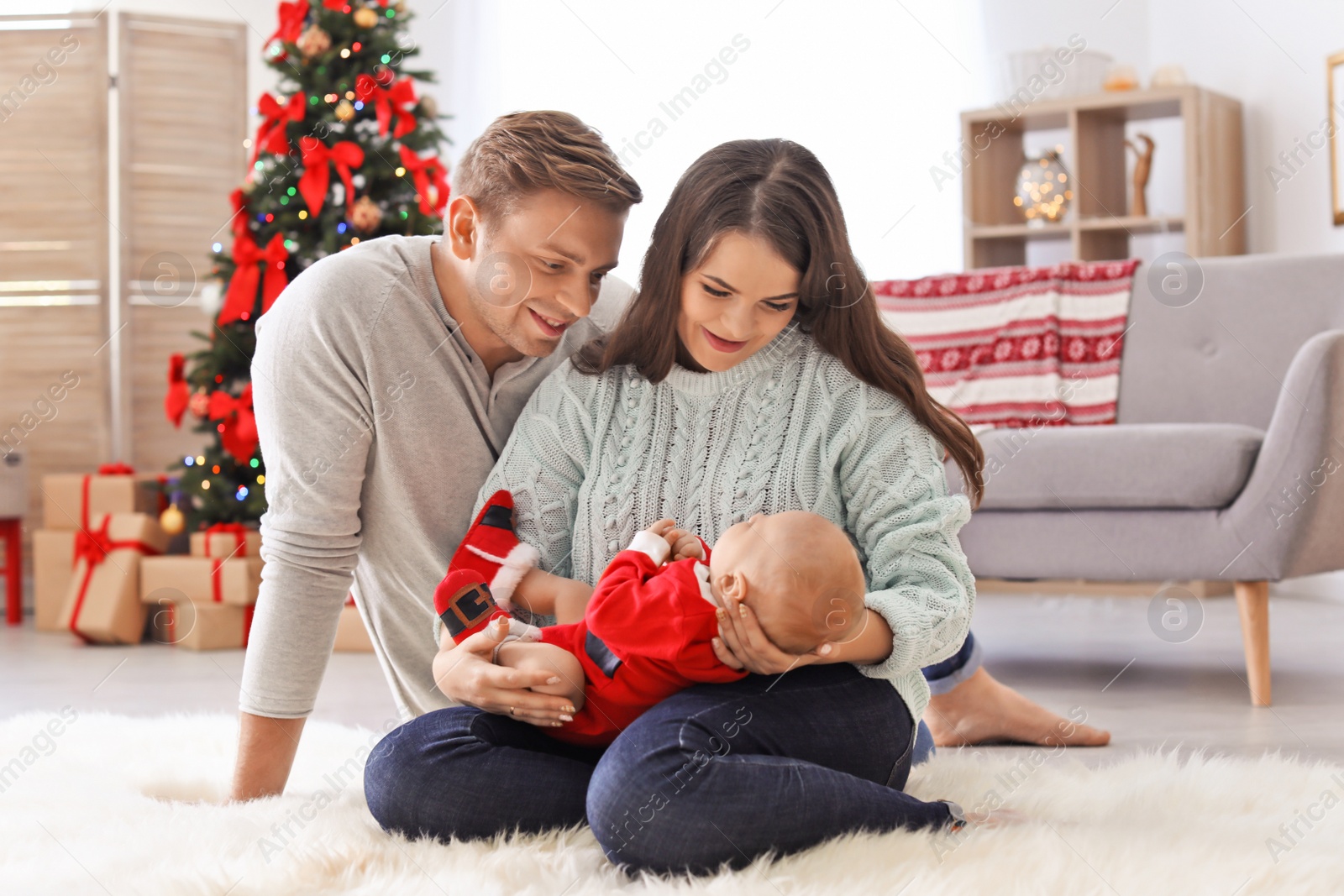 Photo of Happy couple with baby celebrating Christmas together at home