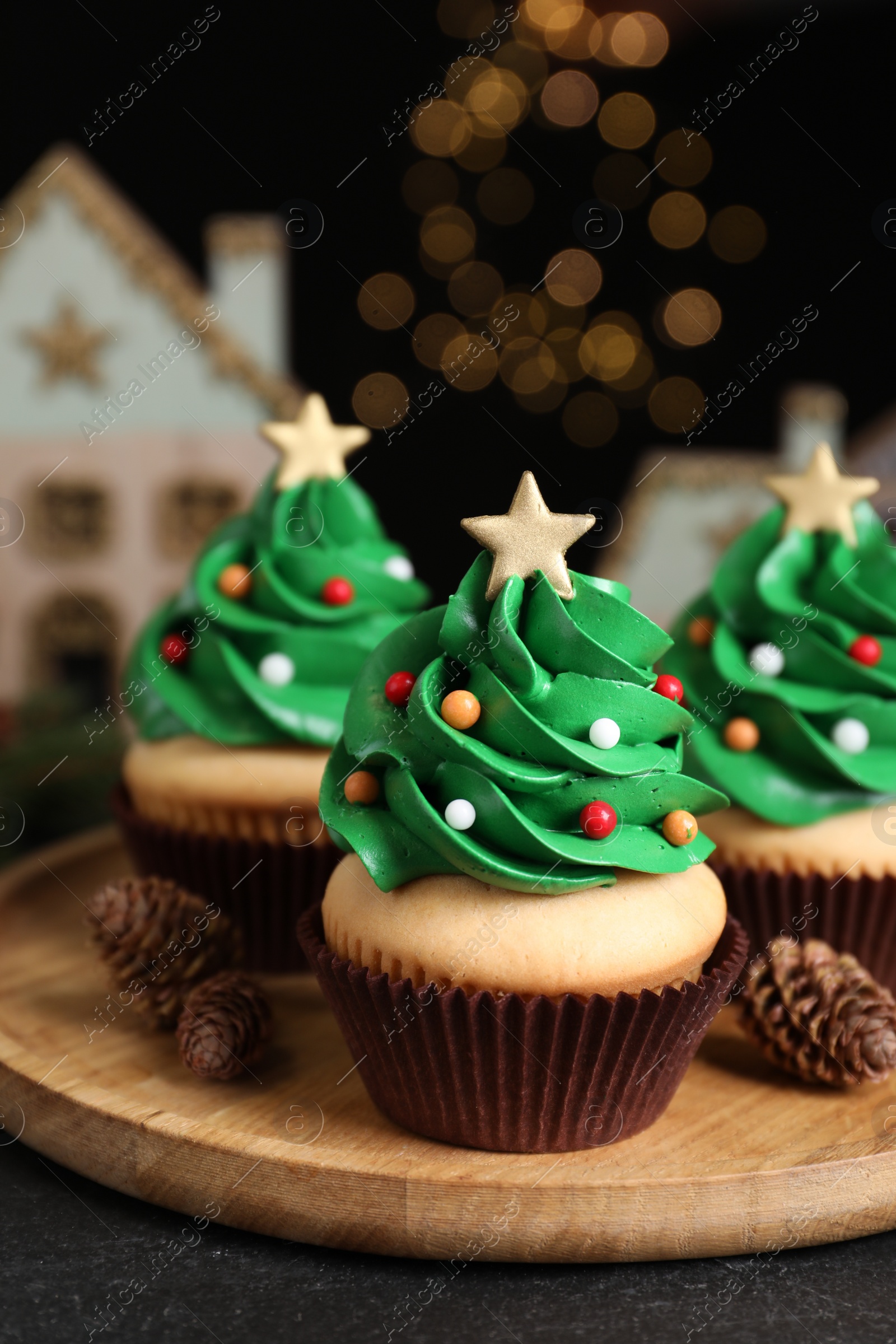 Photo of Christmas tree shaped cupcakes on black table