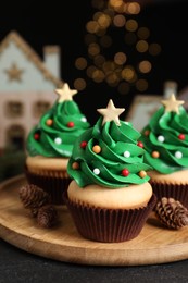 Photo of Christmas tree shaped cupcakes on black table