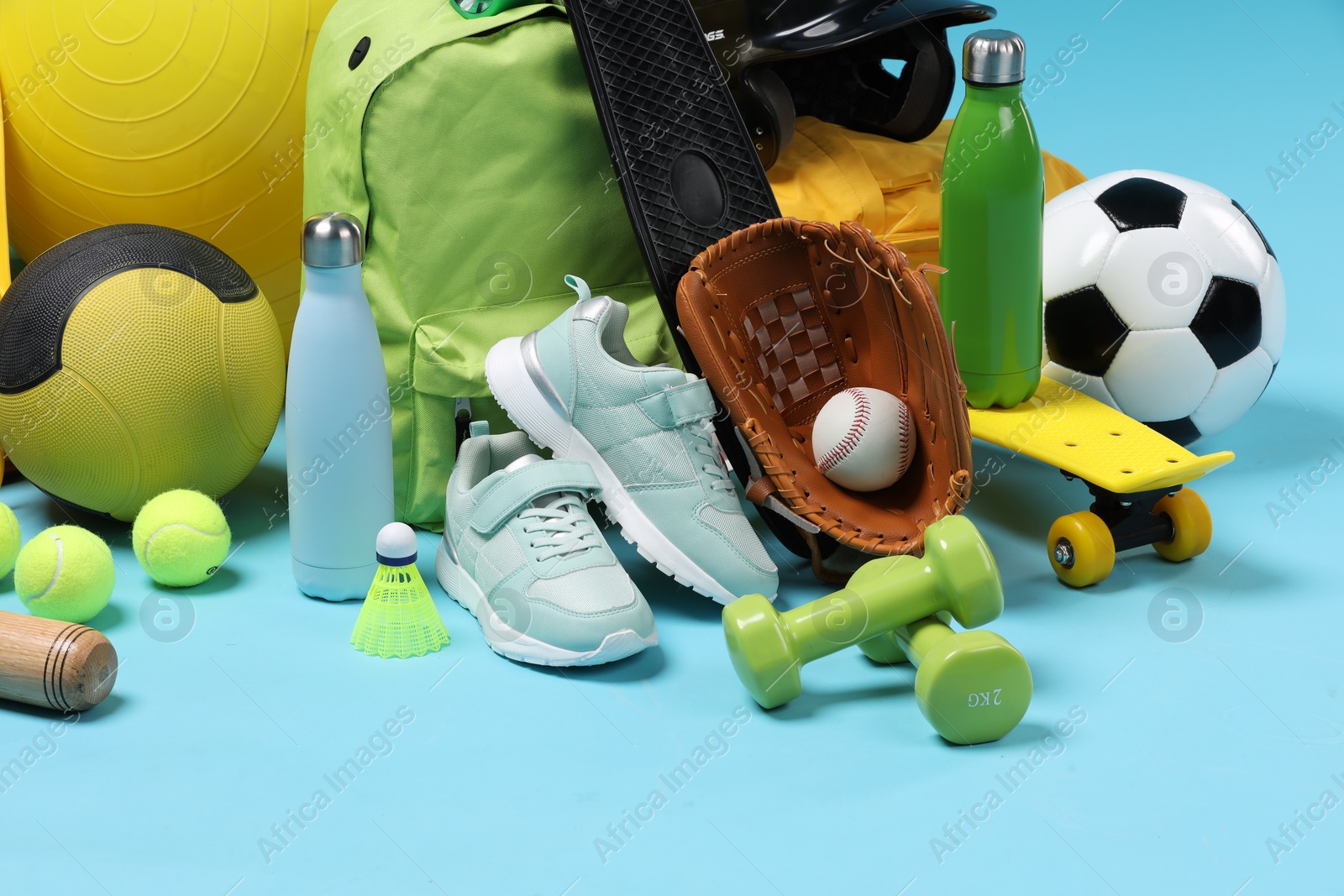 Photo of Many different sports equipment on light blue background, closeup