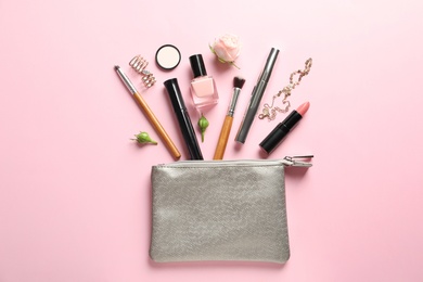 Flat lay composition with products for decorative makeup on pastel pink background