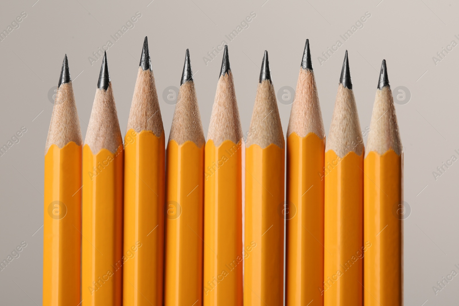 Photo of Many sharp graphite pencils on grey background, macro view