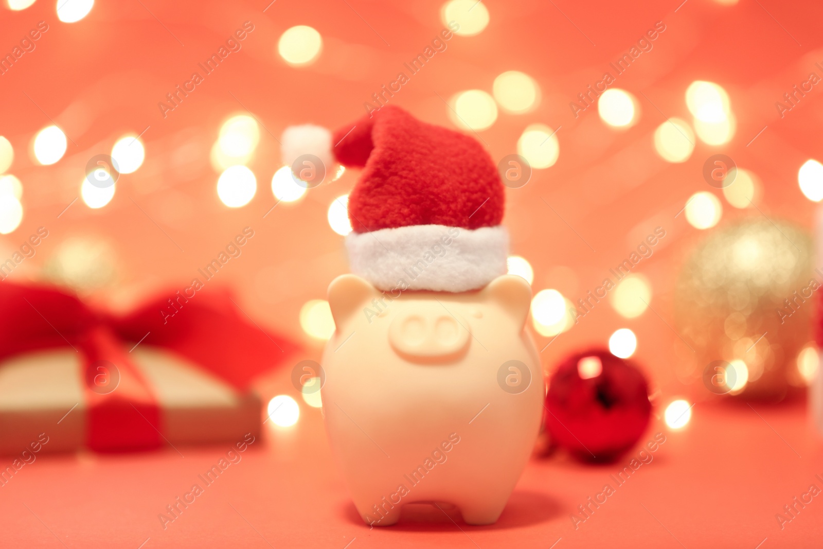 Photo of Piggy bank with Santa hat against blurred background