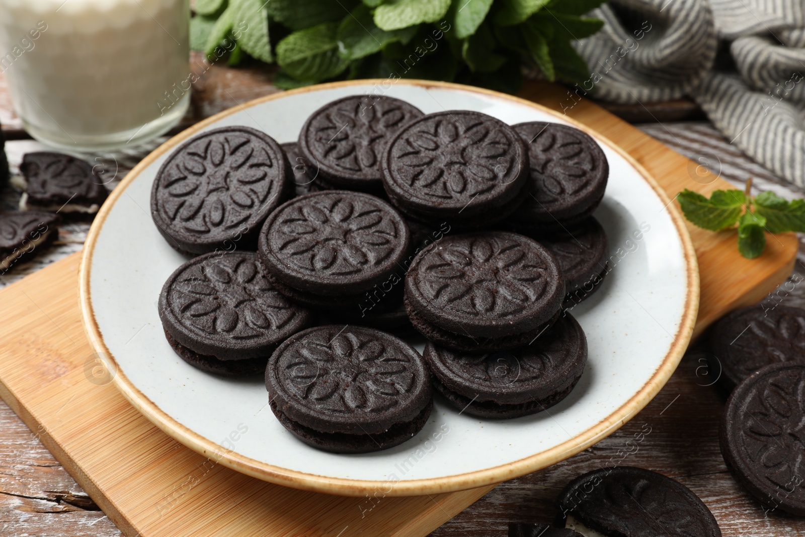 Photo of Plate with tasty sandwich cookies on wooden table, closeup