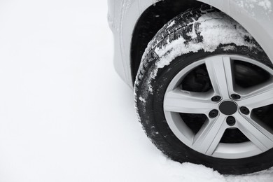 Photo of Car with winter tires on snowy road, closeup. Space for text