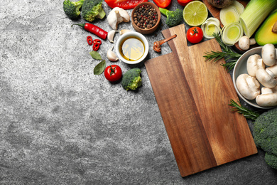 Flat lay composition with fresh products on grey table, space for text. Healthy cooking