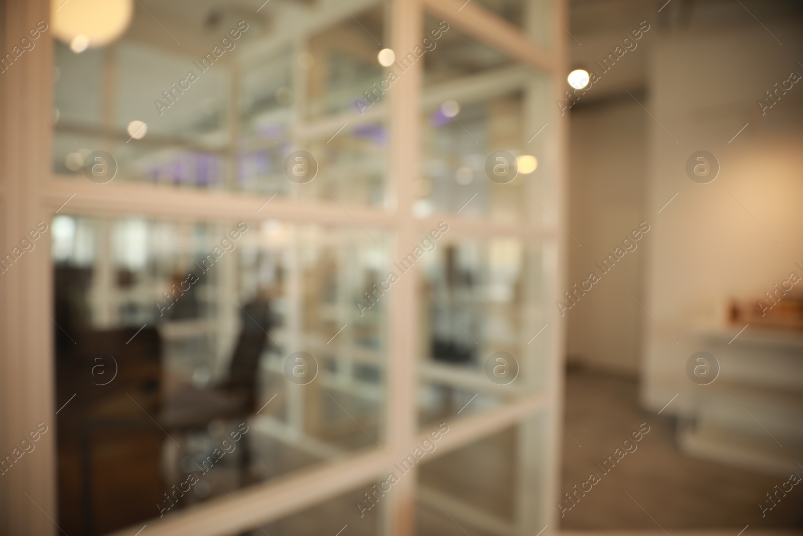 Photo of Blurred view of empty corridor with glass door in company