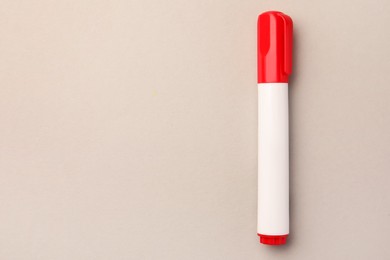 Photo of Bright red marker on beige background, top view. Space for text