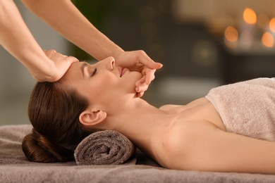 Photo of Beautiful young woman enjoying massage in spa salon