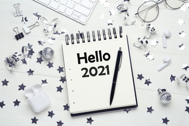 Image of Hello 2021 . Flat lay composition with notebook on white wooden table