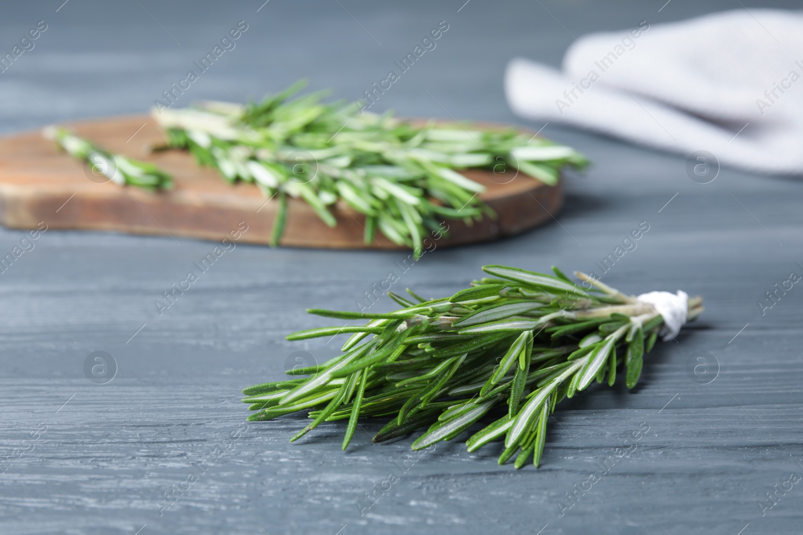 Photo of Fresh green rosemary on blue wooden table, space for text