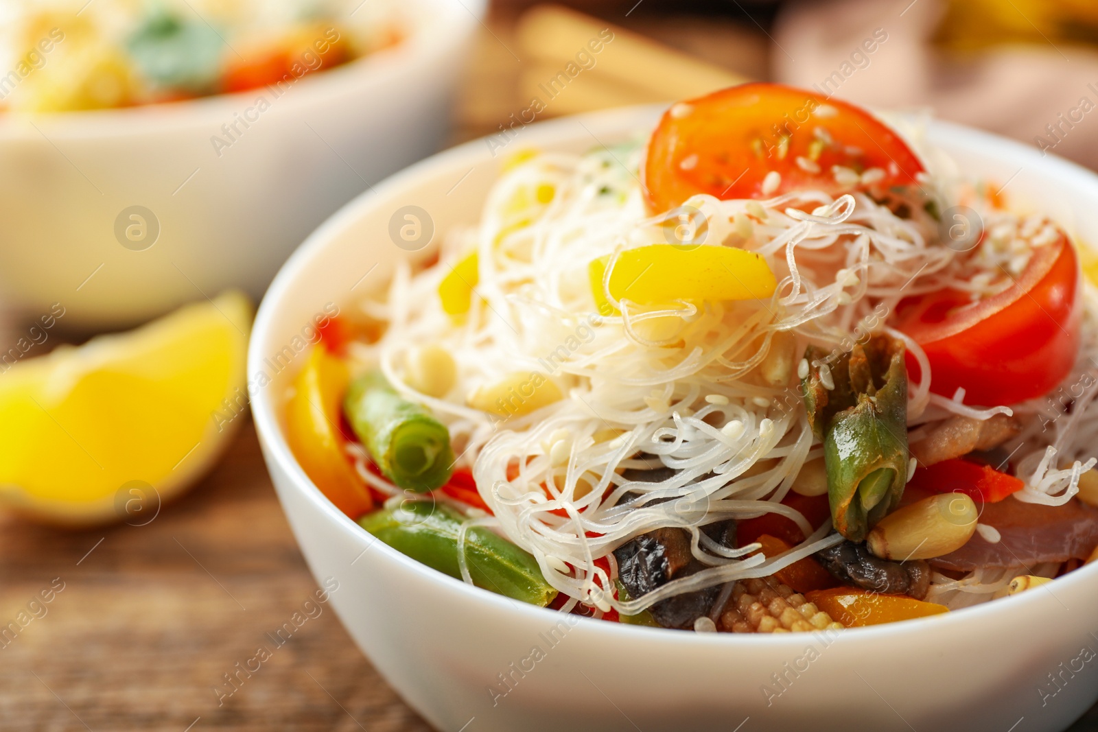 Photo of Tasty cooked rice noodles with vegetables on table, closeup