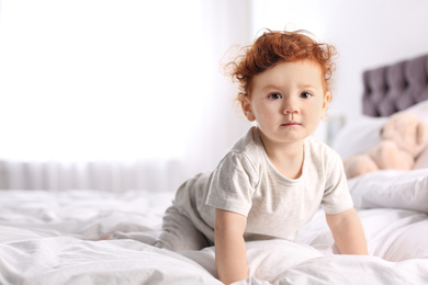 Cute little child on bed at home