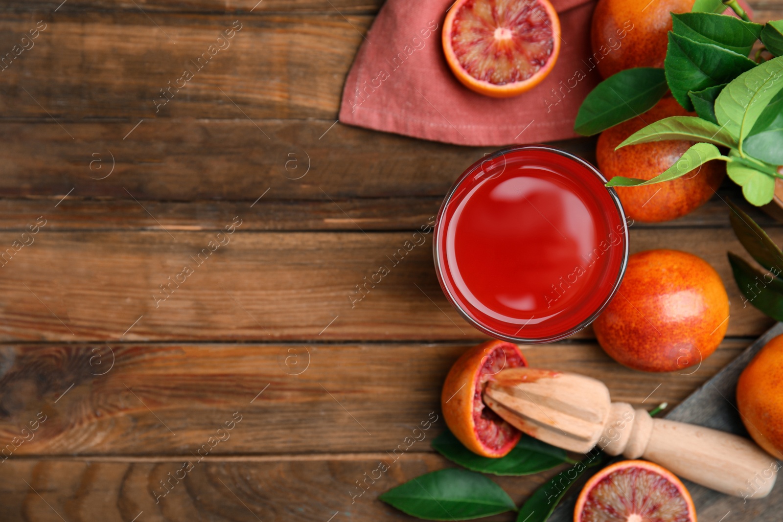 Photo of Tasty sicilian orange juice, fruits and squeezer on wooden table, flat lay. Space for text