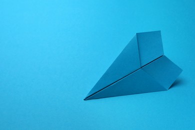 Handmade paper plane on light blue background, space for text