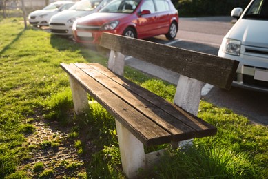 Wooden bench and green grass outdoors on sunny day