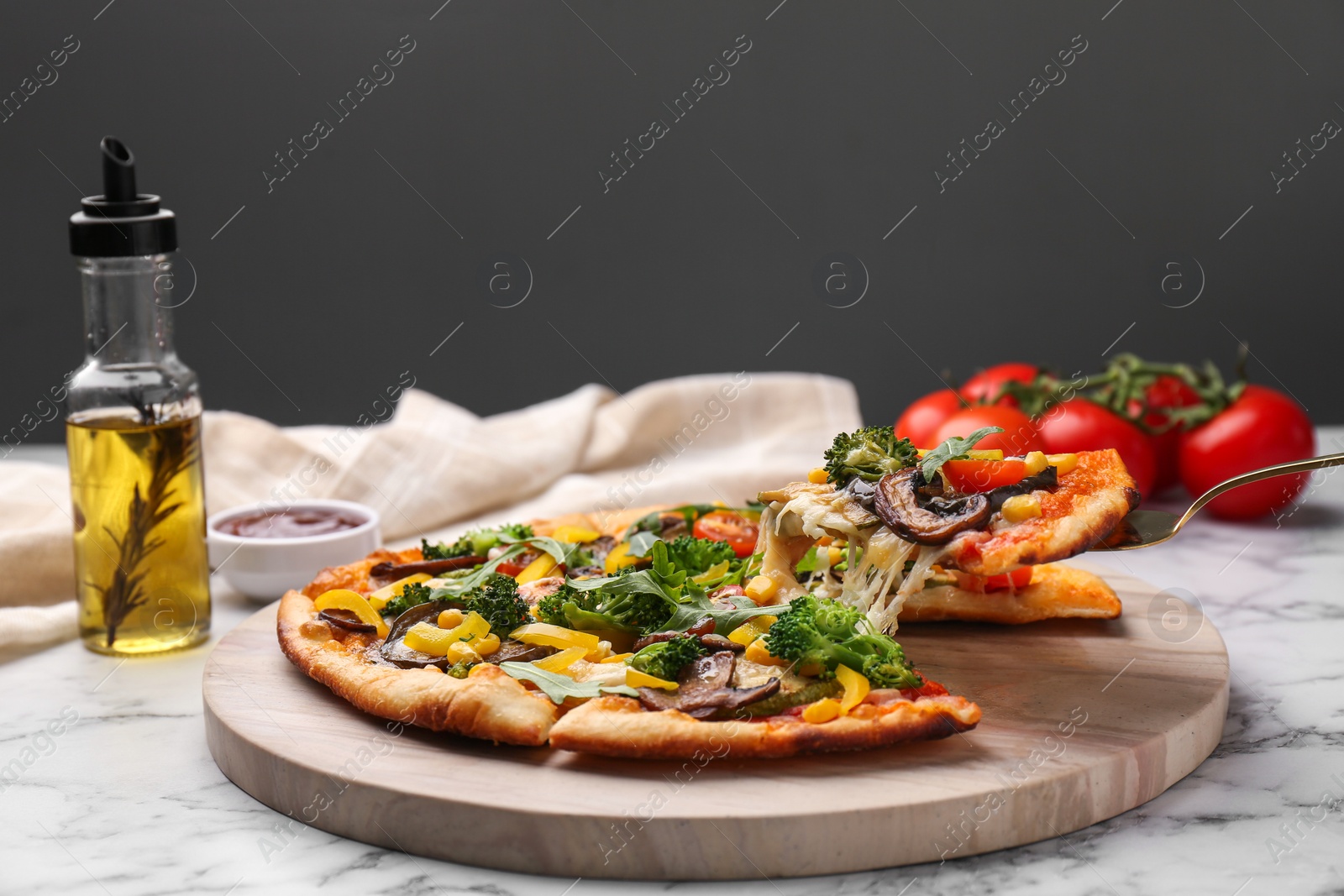 Photo of Taking piece of delicious vegetarian pizza at white marble table, closeup