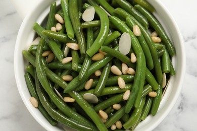 Bowl of tasty salad with green beans on white marble table, top view