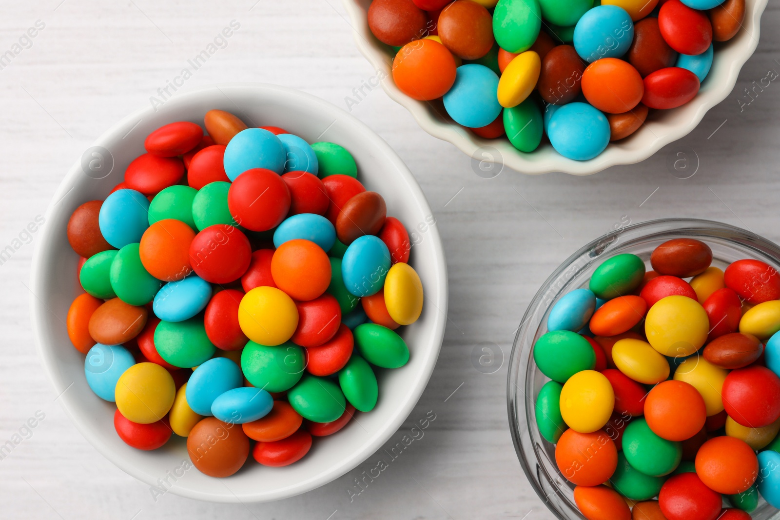 Photo of Tasty colorful candies on white wooden table, flat lay