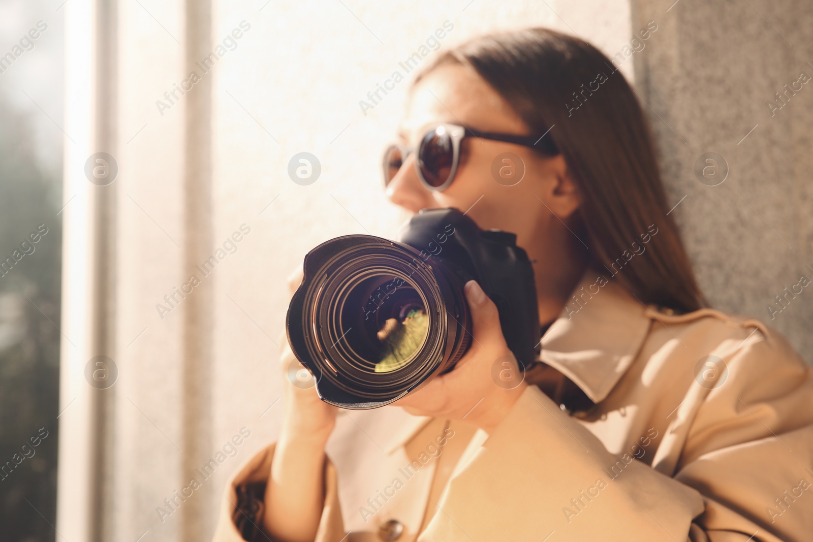 Photo of Private detective with camera spying near building on city street