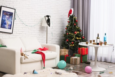 Photo of Messy living room interior with Christmas tree. Chaos after party