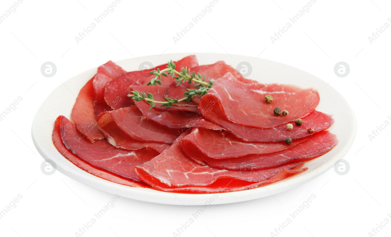 Photo of Slices of tasty bresaola and thyme isolated on white