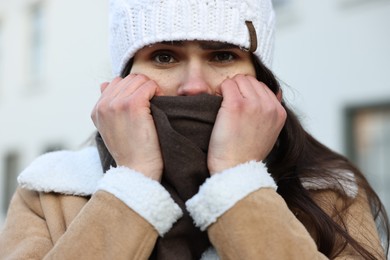 Photo of Sick woman in warm clothes on city street