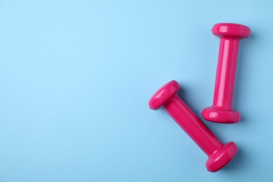 Bright dumbbells and space for text on color background, flat lay. Home fitness