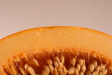 Photo of Cut fresh ripe pumpkin with seeds on beige background, closeup