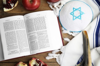 Flat lay composition with Rosh Hashanah holiday symbols on wooden table