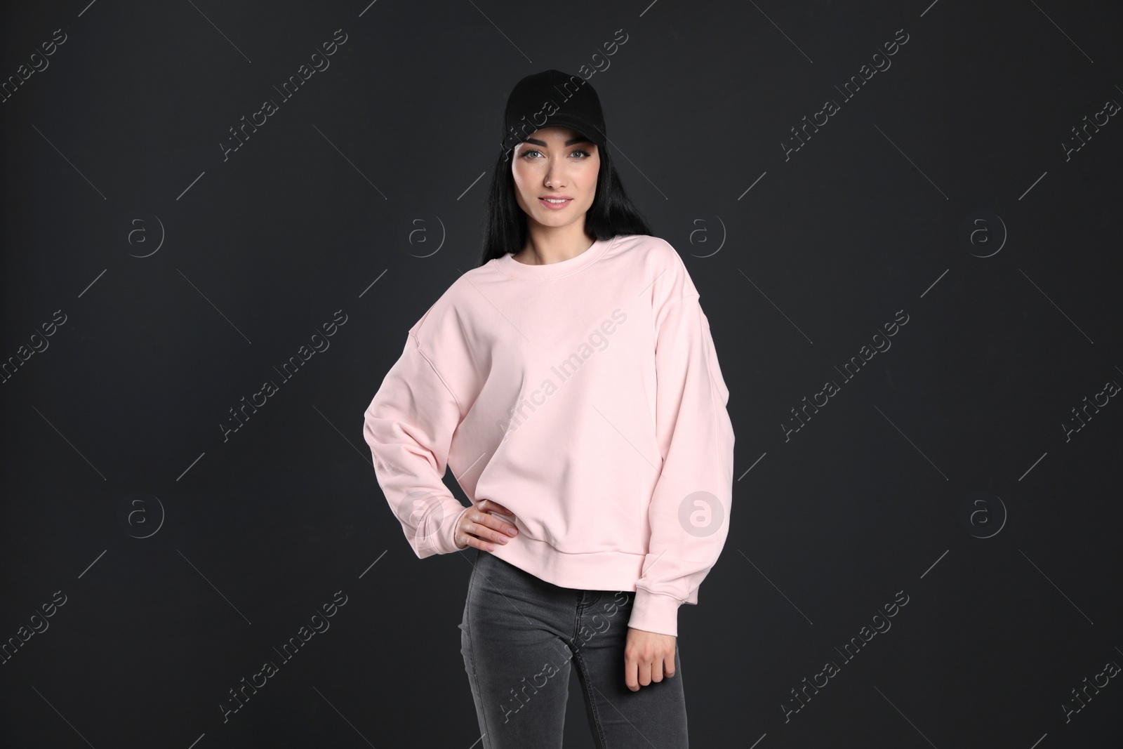 Photo of Portrait of young woman in sweater on black background. Mock up for design