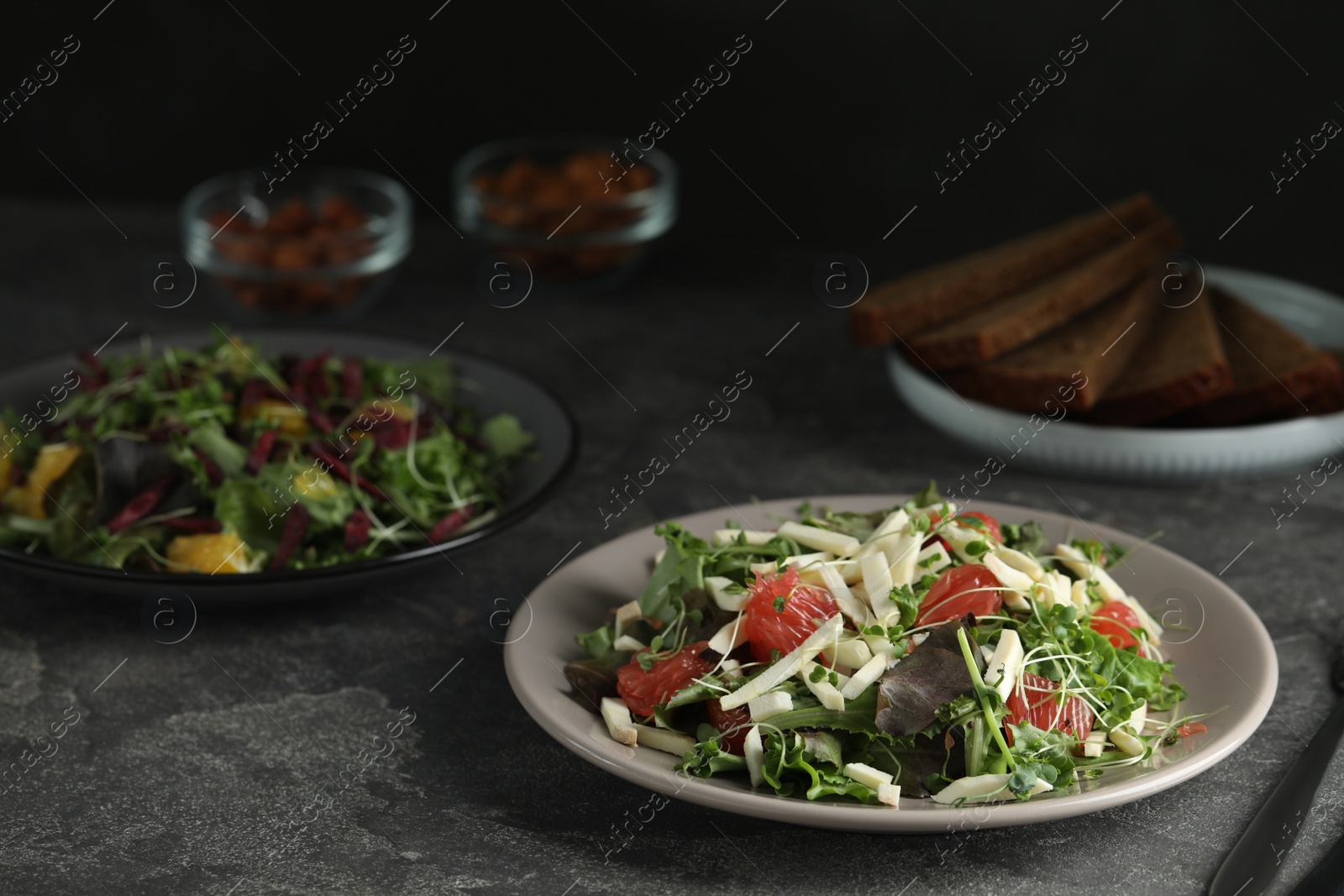 Photo of Delicious carrot salad served on grey table. Space for text