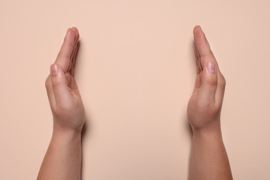 Photo of Woman holding on beige background, closeup of hands. Space for text