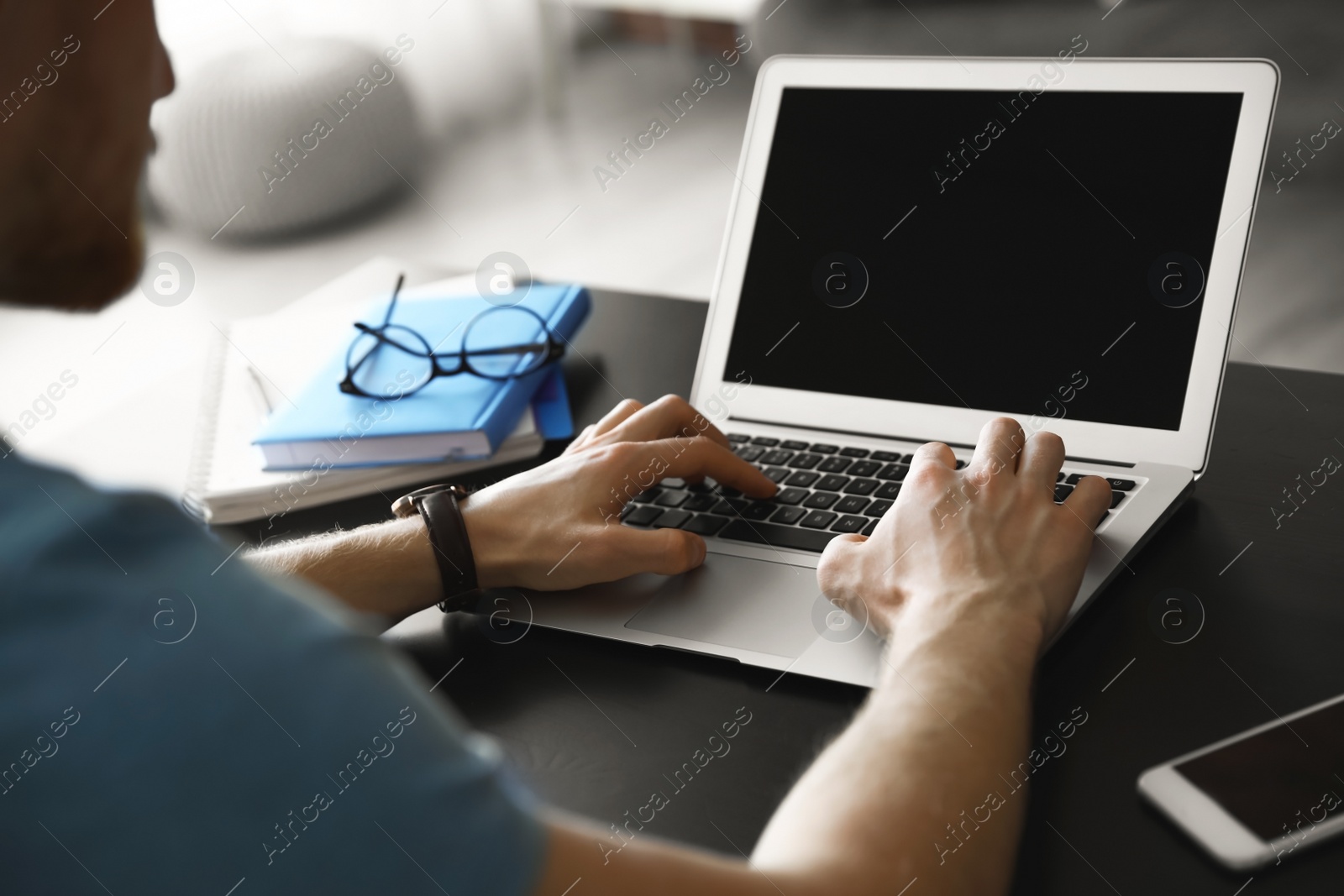 Photo of Man using laptop at table indoors, closeup. Space for text