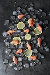 Photo of Flat lay composition with shrimps, lemon slices and ice cubes on dark background