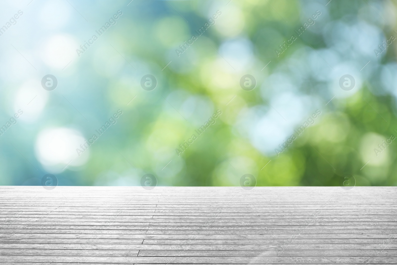 Image of Empty wooden surface against blurred green background. Bokeh effect